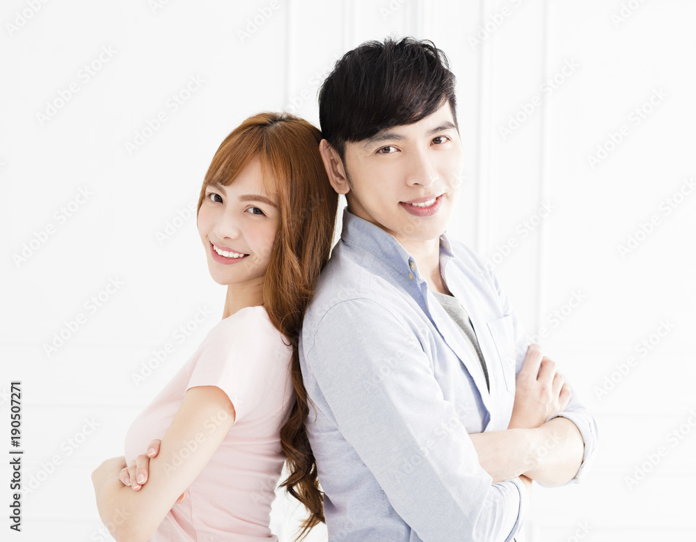happy young asian couple standing in living room