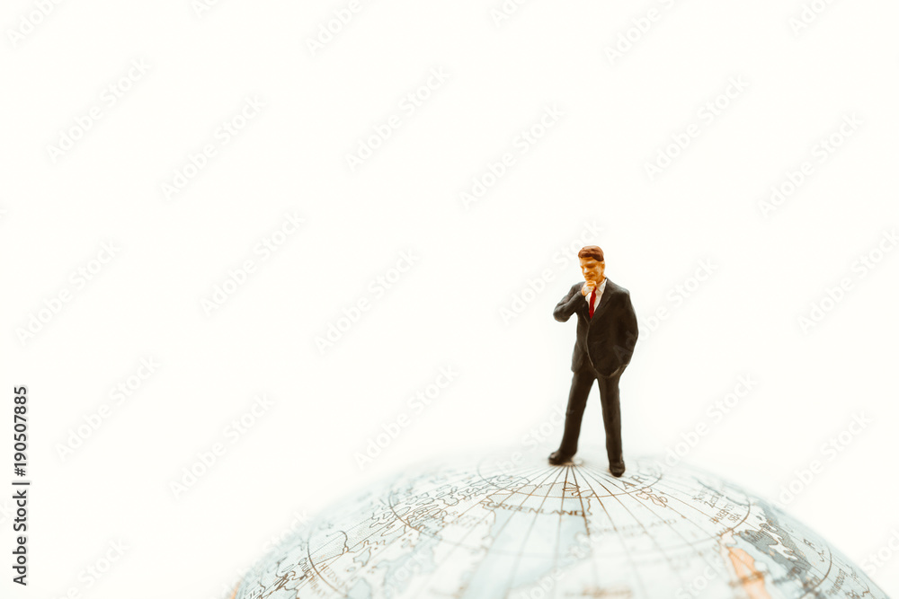 Miniature people, businessman standing on earth using as business management and global connection concept Miniature people, businessman standing on earth using as business management and global connection concept