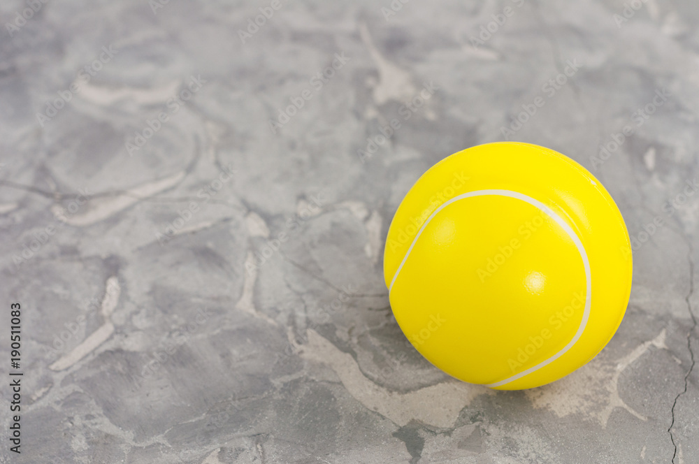 One new yellow soft rubber tennis ball on old worn cement One new yellow soft rubber tennis ball on old worn cement