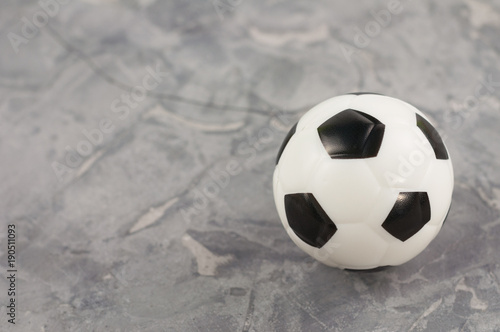 One new black and white soft rubber soccer ball on old worn cement © OlekStock