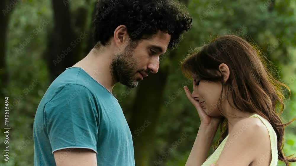 Tenderness, love,affection: Young man comforting his sad girfriend in the park Tenderness, love,affection: Young man comforting his sad girfriend in the park
