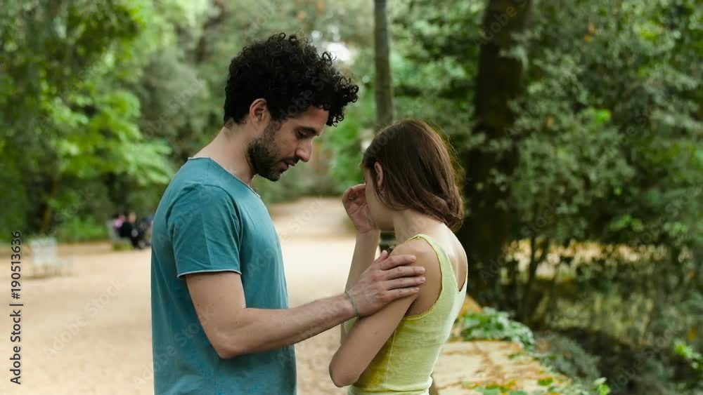 Young man comforting his sad girfriend in the park Young man comforting his sad girfriend in the park