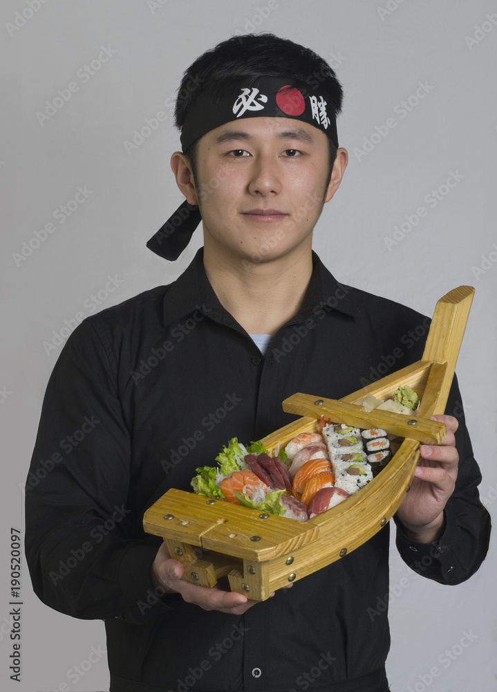 Cocinero de comida japonesa sujeta barco de sushi. Cocinero de comida japonesa sujeta barco de sushi.