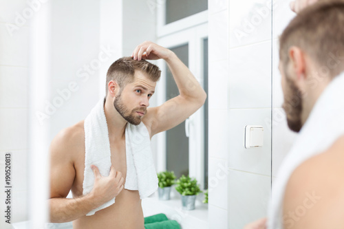 Handsome young man worried about hairloss
