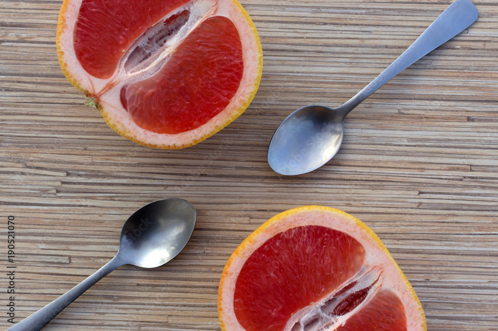 juicy Grapefruit with spoon on wooden background