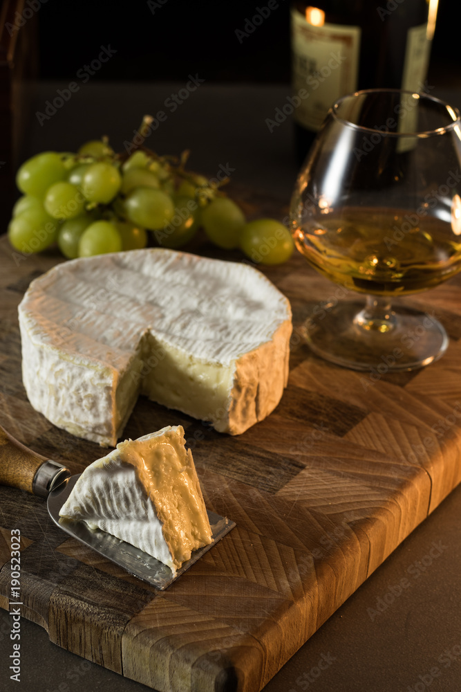 Still life of grapes, Cognac and french cheese on a wooden board Still life of grapes, Cognac and french cheese on a wooden board