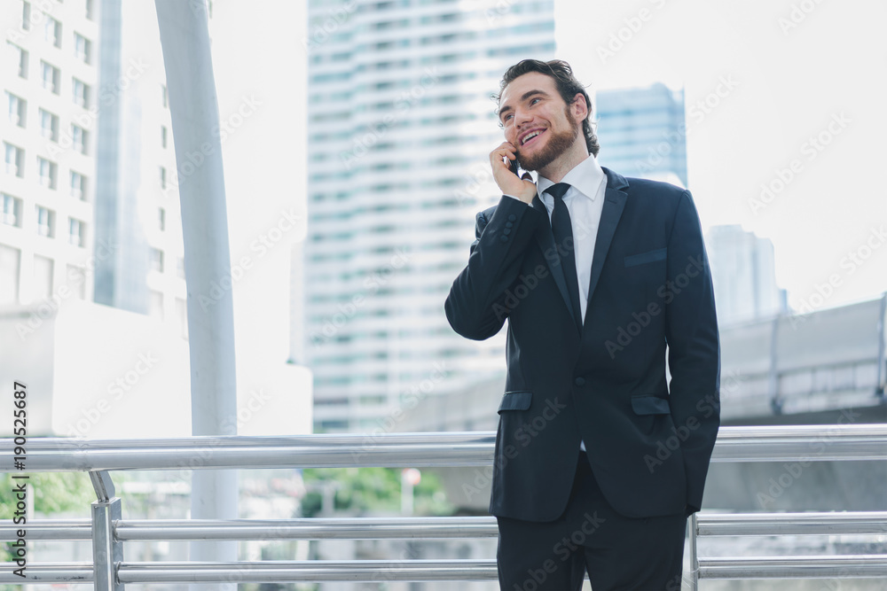 Smart businessman in full suit standing outdoors using smartphone talk business project in cityscape background Smart businessman in full suit standing outdoors using smartphone talk business project in cityscape background