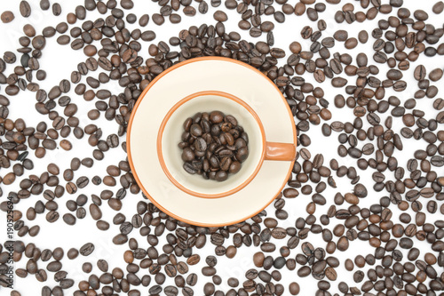 top view closeup of a coffee cup filled with roasted coffee beans o of roasted coffee beans isolated on white background . © oatautta