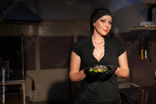 woman Cook prepares a burger in the kitchen photo