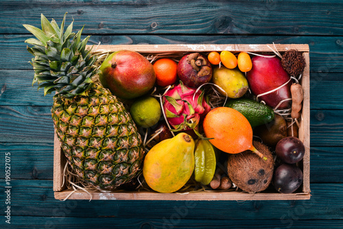 Tablou pe pânză Tropical fruit in a wooden box