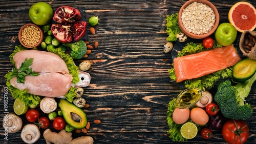 Fototapeta Naklejka Na Ścianę i Meble -  Healthy food background. Concept of Healthy Food, Chicken Fillet, Raw Meat, Fish, Avocado, Broccoli, Fresh Vegetables, Nuts and Fruits. On a wooden background. Top view. Copy space.
