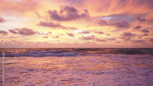 Colorful sunset on the tropical beach with beautiful sky, clouds, soft waves