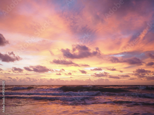 Colorful sunset on the tropical beach with beautiful sky, clouds, soft waves. © l3ank
