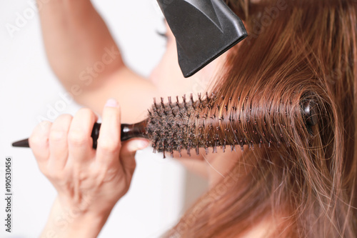 Making hairstyle using hair dryer yourself. photo