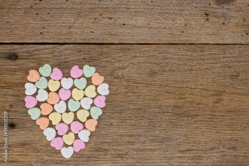 Heart filled with conversation hearts on barn wood