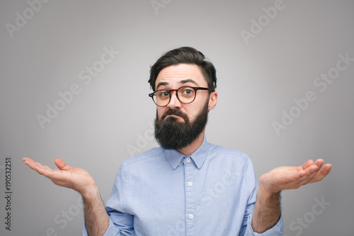 фотографія Confused man holding hands apart
