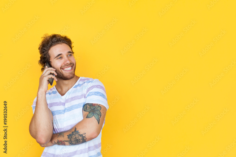 Smiling tattooed man speaking on phone Smiling tattooed man speaking on phone