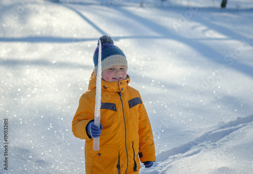 European boy with big icicle on a walk
