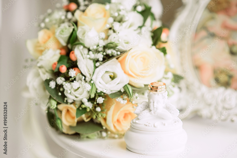 gold wedding rings on bride's bouquet of white and delicate beige roses, wedding decor gold wedding rings on bride's bouquet of white and delicate beige roses, wedding decor