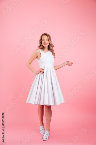 Cheerful young woman standing isolated