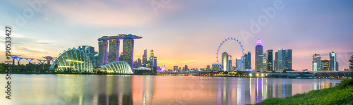 Business city district of Singapore Skyline. At marina bay sand and the garden by the bay on sunset with modern tower building with lighting and colorful of sky cloud.
