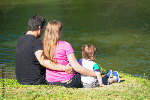 family sitting by the lake