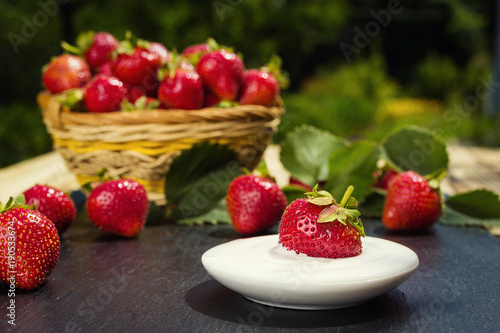 strawberries with cream on stone background  delicious first class organic fruit as a concept of summer vitamins