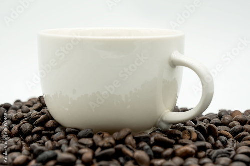 white coffee cup and coffee beans isolated on white background .