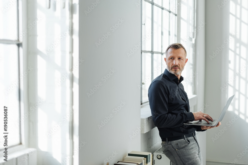 Fototapeta premium Relaxed businessman using a handheld laptop
