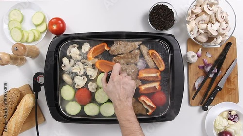 Top view of Cook takes the lid from the grill and a lot of steas is covering the frame photo