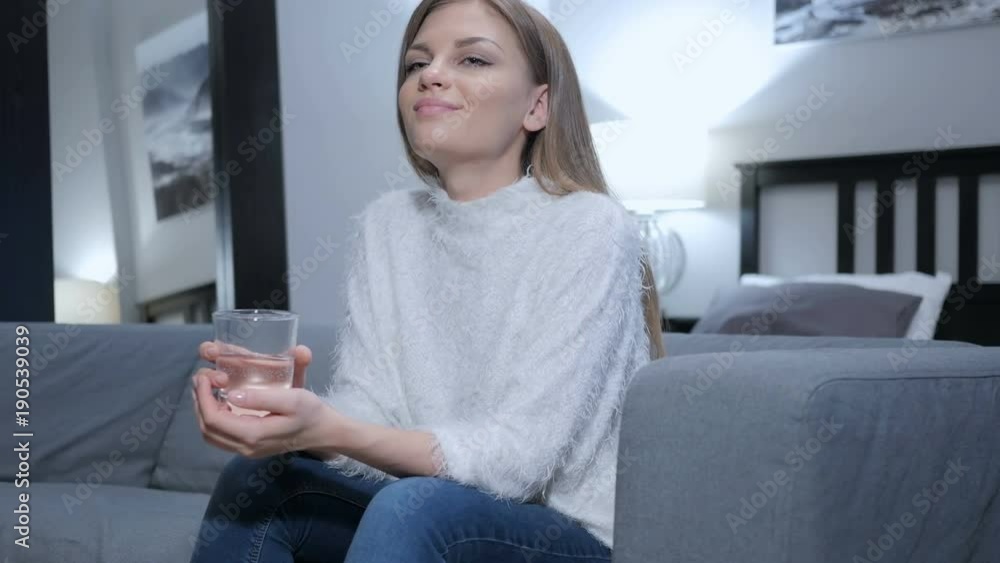 Relaxing Woman Drinking Water while Sitting on Couch Relaxing Woman Drinking Water while Sitting on Couch