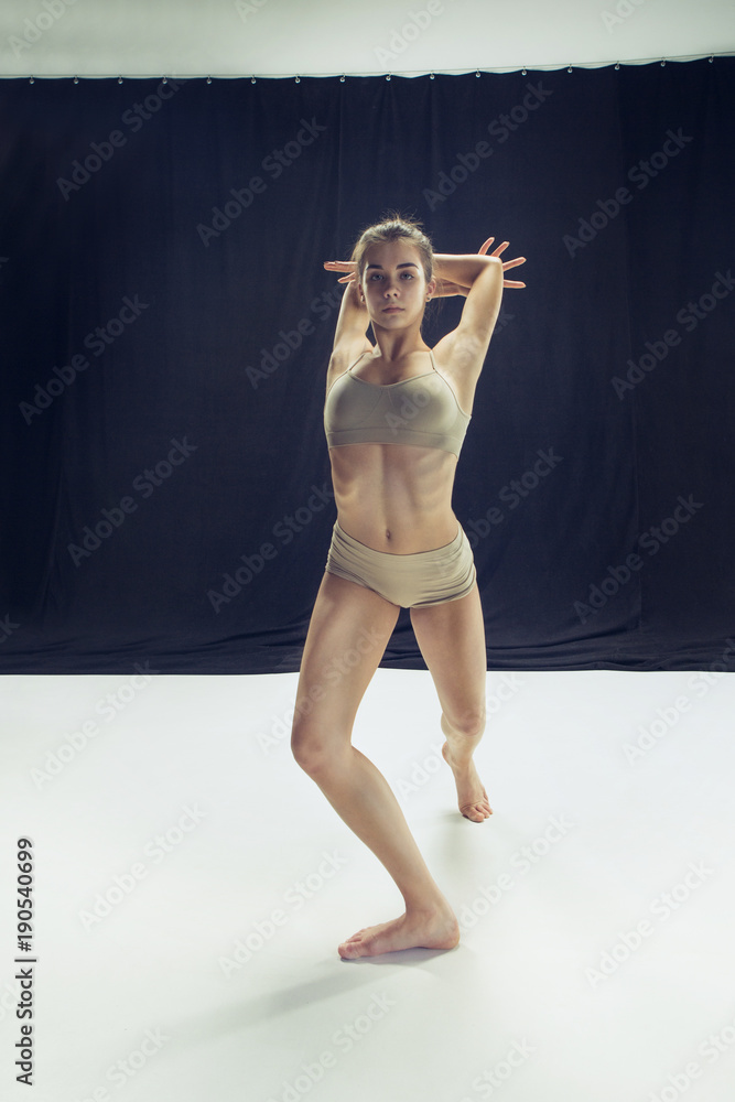 Young teen dancer ion white floor background.