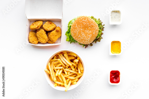 Fast food. Chiken nuggets, burgers and french fries on white background top view