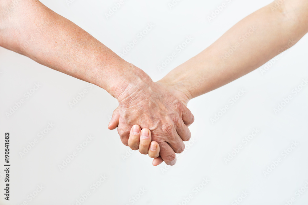 close up of senior and young woman holding hands close up of senior and young woman holding hands