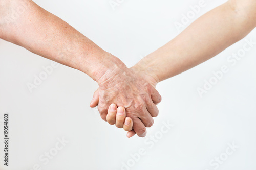 close up of senior and young woman holding hands