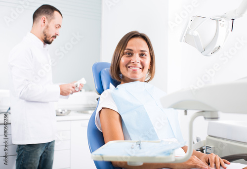 Young female is sitting satisfied after treatment in dental office