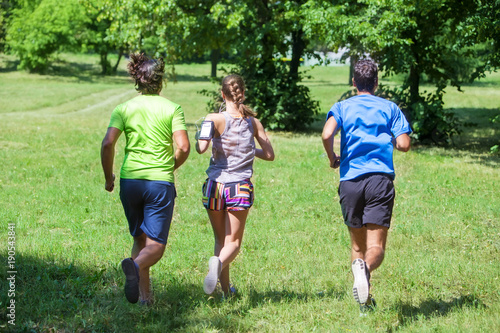 Woman and two young men run...