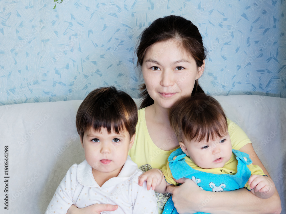 Happy smiling woman with two little girls, multinational family with Asian mother and Caucasian daughters