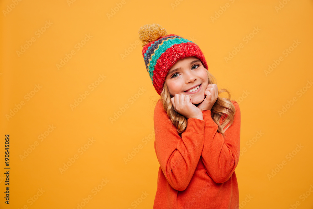 Pleased girl in sweater and hat reclines on her arms Pleased girl in sweater and hat reclines on her arms