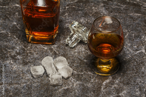 A glass of cognac or whiskey on the background of marble.
