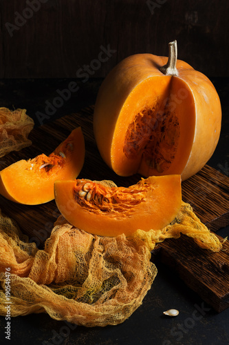 The pumpkin is sliced into slices on a dark background. selective focus.