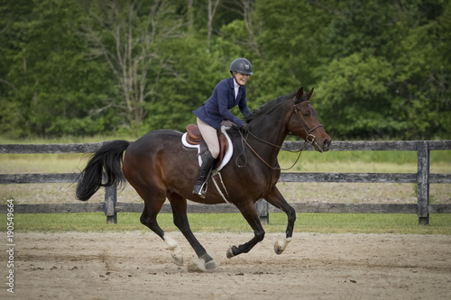 Rider laughs while galloping bay horse
