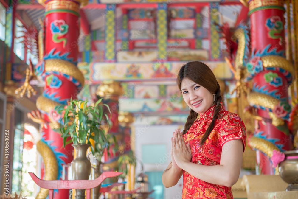 Portrait of beautiful asian woman in Cheongsam dress ,Thailand people,Happy Chinese new year concept,Make hand sawasdee