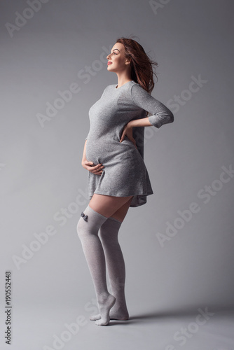 Happy smiling young pregnant woman touching her Belly. Pregnancy concept. Mom Expecting Baby. photo