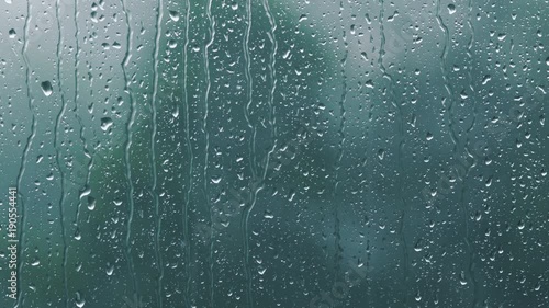 real rain drops sliding on window glass photo