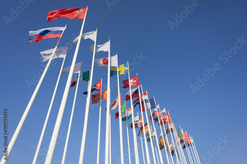 World Flags Blowing In The Wind On blue Sky Background. Flags of many nation photo