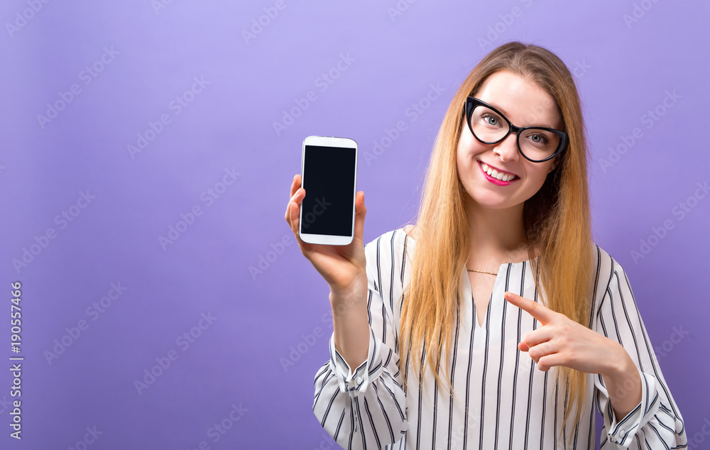 Young woman holding out a cellphone in her hand