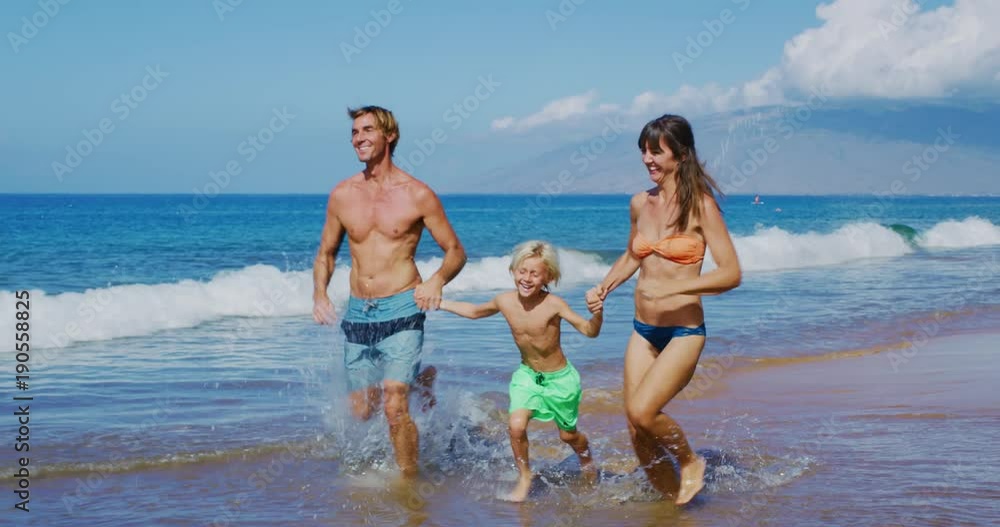 Happy young family enjoying day at the beach on vacation Happy young family enjoying day at the beach on vacation
