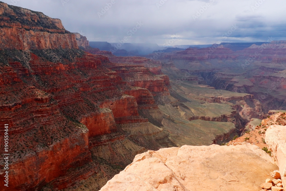 Beautiful nature landscape with cloudy blue sky over the amazing relief structures in the Grand Canyon National Park, Arizona, USA.Scenic areal view from Kaibab trail, South Rim with upcoming rain.
