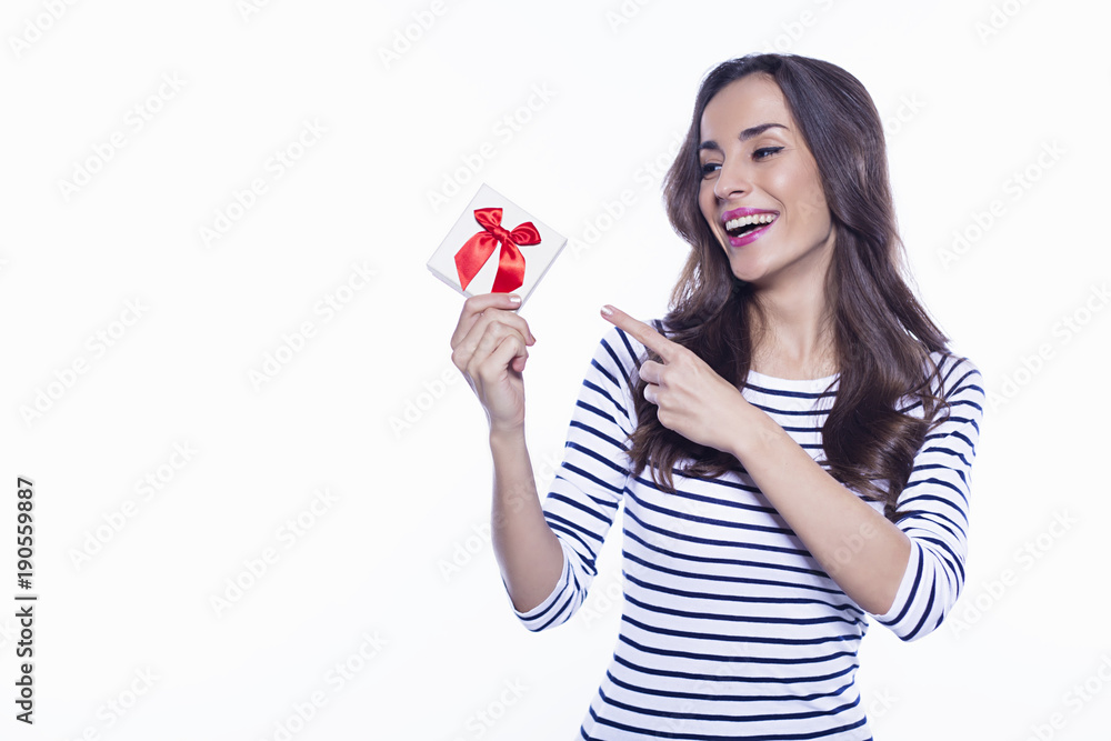 Beautiful young smiling woman in casual clothes holding a gift Beautiful young smiling woman in casual clothes holding a gift